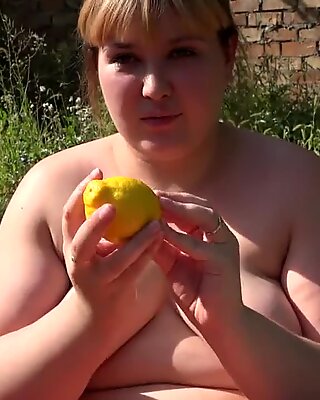 Wanita gemuk di taman mendorong keluar lemon berbulu berbulu memek