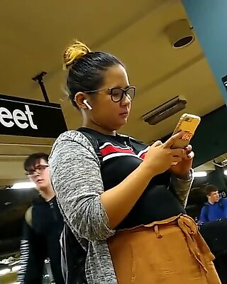 Söt knubbig filipina tjej med glasögon väntar på tåg